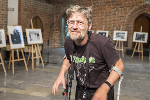 Andrzej Talewicz na tle swojej wystawy "Miejsca oporu"